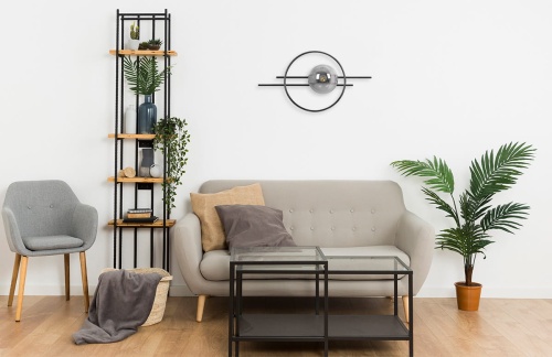 Designerski kinkiet Astra K-5340 z kulistym, przydymionym kloszem i czarną geometryczną konstrukcją – nowoczesna dekoracja ścienna  zamontowana na ścianie w salonie