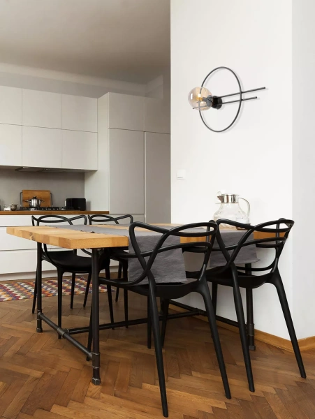 inkiet Corsa K-5346 z bursztynowym kloszem i geometryczną czarną ramą – nowoczesne oświetlenie ścienne w minimalistycznym stylu. Zamontowany w jadalni