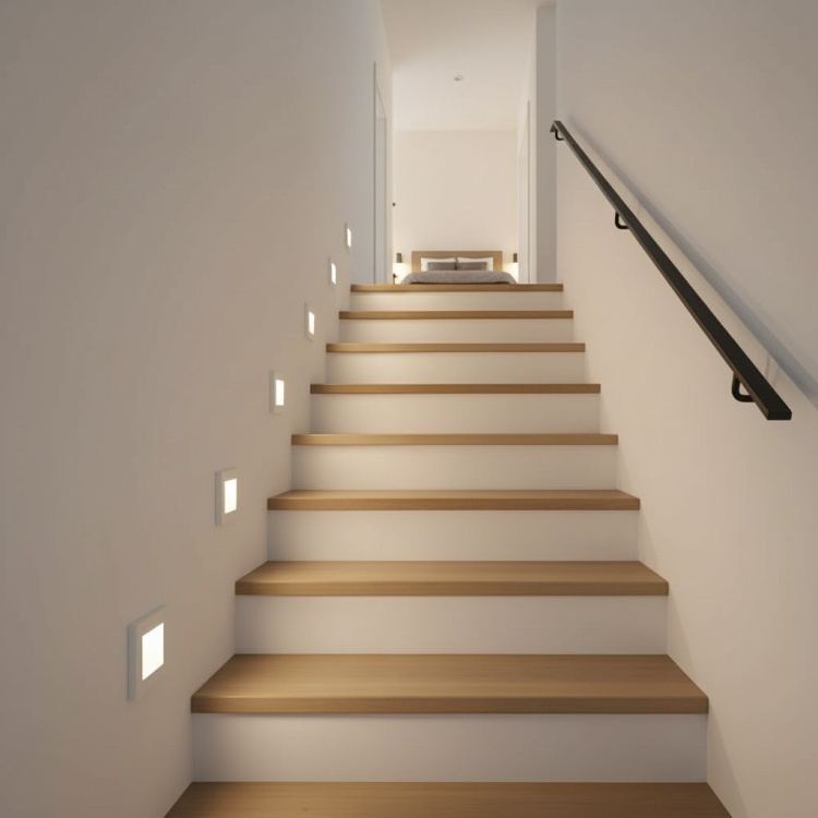 białe lampki schodowe na klatce.