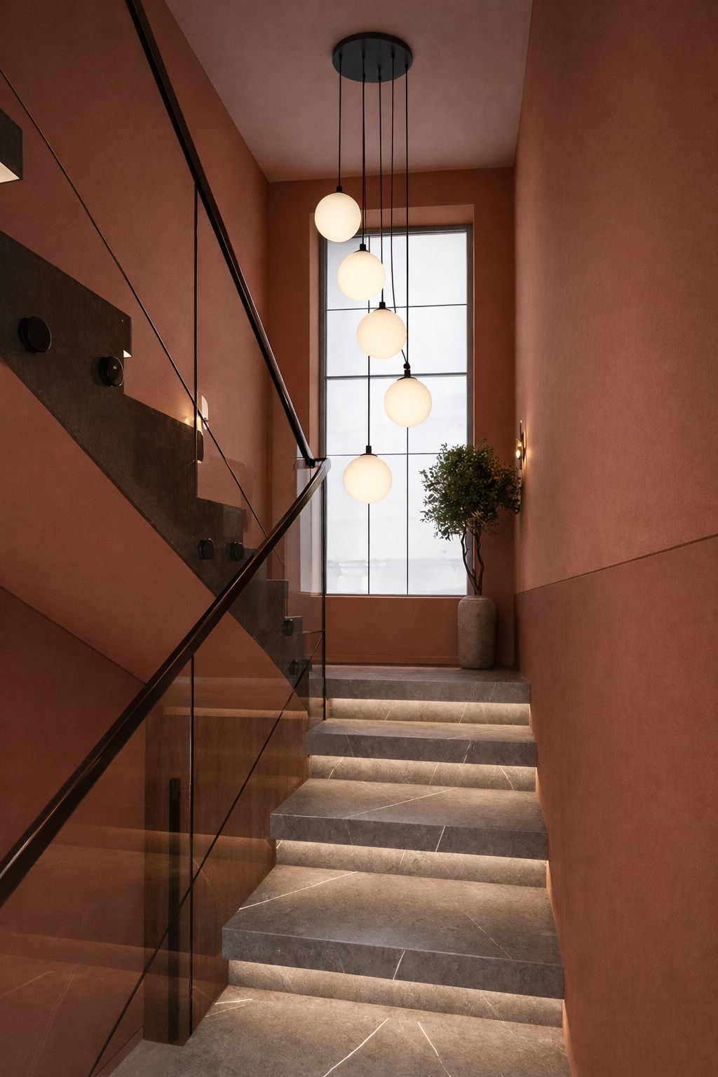 Lampa z pięcioma kloszami zawieszona przy schodach.